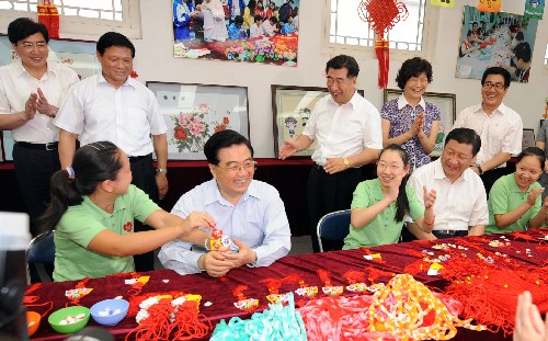 這是胡錦濤在北京市什剎海街道殘疾人溫馨家園的手拉手職業(yè)康復(fù)站里興致勃勃地同殘疾人朋友一起編織中國結(jié)。 新華社記者鞠鵬攝