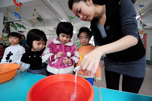 4月7日,廣州市白云區(qū)信孚澤德幼兒園大A班的老師(右一)向清水中加入消毒粉,準(zhǔn)備指導(dǎo)小朋友們洗手。針對兒童易感染手足口病和其它春季流行病的情況,廣州許多幼兒園都采取開展晨檢,定期對教室、桌椅、玩具進(jìn)行消毒,培養(yǎng)小朋友養(yǎng)成勤洗手的衛(wèi)生習(xí)慣等措施進(jìn)行預(yù)防。新華社記者 陳曄華 攝