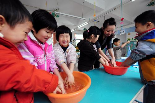 4月7日,廣州市白云區(qū)信孚澤德幼兒園大A班的小朋友們在老師的指導(dǎo)下用消毒水洗手。新華社記者 陳曄華 攝