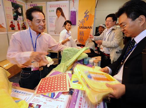 4月8日,臺(tái)商張英斌(左一)在廈門舉行的第十三屆臺(tái)交會(huì)上推介臺(tái)灣紡織品。新華社記者 張國(guó)俊 攝