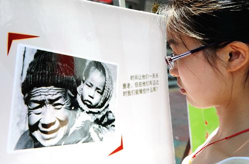 5月10日,一名女孩在街頭觀(guān)看有關(guān)母親節(jié)的圖片展覽。當(dāng)日是母親節(jié),福州街頭社區(qū)紛紛開(kāi)展各種慶祝母親節(jié)活動(dòng),人們以各自不同的方式感恩母親。新華社記者 張國(guó)俊 攝