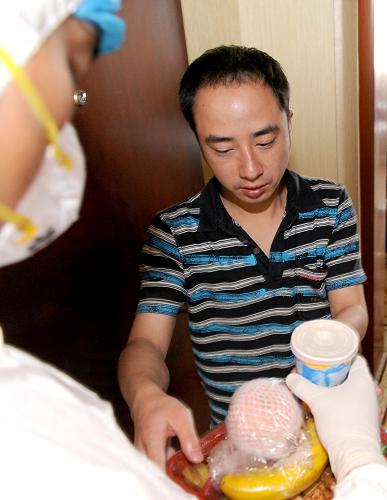 5月16日,甲型H1N1流感集中觀察點(diǎn)——位于成都市龍泉驛區(qū)的某賓館內(nèi),工作人員為即將解除醫(yī)學(xué)觀察的接觸者送飯。新華社記者 陳?ài)?攝