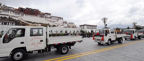 6月29日,黨中央、國務院為西藏行政村配備的農(nóng)用運輸車從布達拉宮前駛過。新華社記者 格桑達瓦 攝