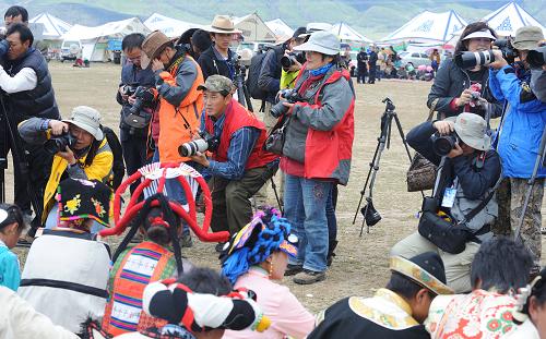 游客在當(dāng)雄草原拍攝賽馬節(jié)上的牧民服飾(8月21日攝)。新華社記者 格桑達(dá)瓦 攝