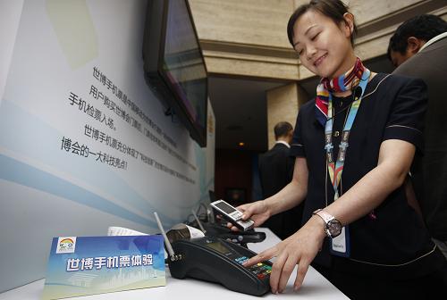 10月13日,一位工作人員正在演示如何將票務信息下載到手機SIM卡中。新華社記者 裴鑫 攝