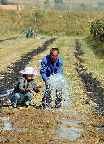 10月14日,山東乳山市農民在田間澆水準備播種小麥。新華社發(fā)(劉國賢 攝)