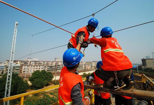 10月15日,中鐵二局電務公司的施工人員正在昌九城際鐵路九江段進行掛網(wǎng)架線施工。新華社發(fā)(胡國林 攝)