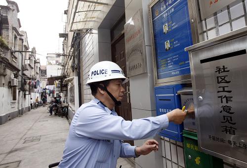 一位民警在上海盧灣區(qū)一個(gè)弄堂內(nèi)開啟居民意見箱(5月17日)。新華社記者 張明 攝