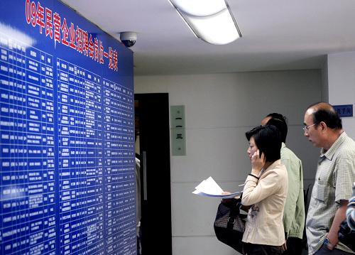 求職者在上海2009年民營企業(yè)招聘會(huì)上查看崗位信息(5月15日攝)。新華社記者 劉穎 攝