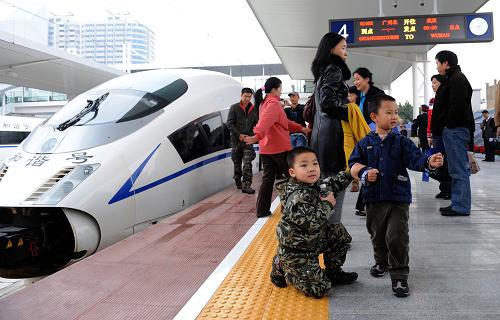 12月26日,乘客在廣州開往武漢的G1002次列車前留影。當(dāng)日,武廣高鐵正式通車運營,標(biāo)志著我國步入高速鐵路新時代。新華社記者 盧漢欣 攝