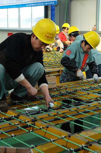 1月26日,技術(shù)工人在軌道板模胎上綁扎鋼筋。新華社記者 黃深鋼 攝
