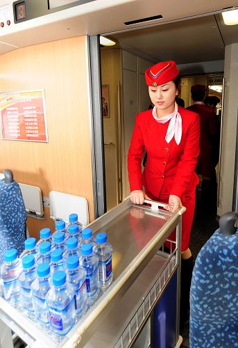 1月29日,一位乘務員在試運行的“和諧號”列車上準備飲用水。新華社記者 王頌 攝
