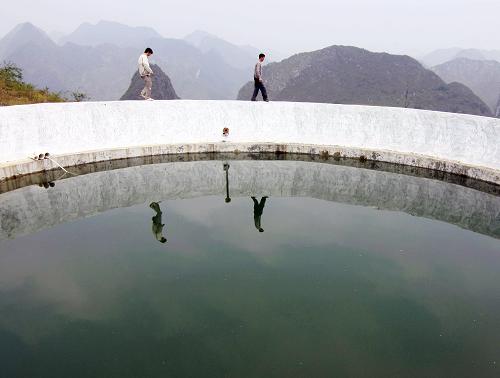 4月11日,廣西鳳山縣袍里鄉(xiāng)央峒村村民張遠(yuǎn)初(右)和東蘭縣蘭木鄉(xiāng)央佑村村民張敬科一起檢查公共水池蓄水情況。新華社發(fā)(周恩革 攝)