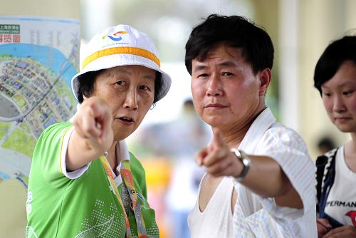 7月10日,60歲的志愿者李林芳正在為游客指路。新華社記者任軍川攝