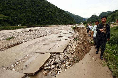 8月10日,在葦沙河鎮(zhèn)錯草村的被毀公路旁,當?shù)馗刹咳罕娧膊闉?zāi)情。地處鴨綠江畔的吉林省臨江市葦沙河鎮(zhèn),在此次百年不遇的洪災(zāi)中受損嚴重。7月31日凌晨1時至15時,臨江市轄區(qū)內(nèi)出現(xiàn)了165.3毫米降雨,超過有氣象記錄以來的極值,導致山洪暴發(fā)。洪災(zāi)造成全市12個鄉(xiāng)鎮(zhèn)的47個行政村通訊、供電中斷;主要城區(qū)(12平方公里)及10個鄉(xiāng)鎮(zhèn)的57個行政村供水中斷;全市因災(zāi)死亡9人,失蹤3人。此次洪災(zāi)造成直接經(jīng)濟損失總計25.39億元。新華社記者 袁滿 攝