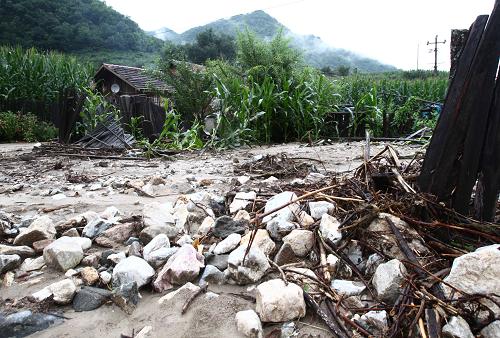 8月10日,在葦沙河鎮(zhèn)錯草村的村民院落里,圍墻被毀、碎石遍地。新華社記者 袁滿 攝