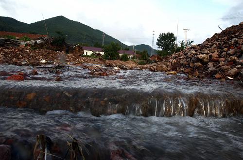 8月10日,在葦沙河鎮(zhèn)的公路上,從山上流下的積水在公路上匯成湍急的溪水。新華社記者 袁滿 攝