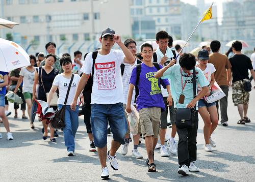 8月14日,在上海世博園五號門,一群游客走向入口處。新華社記者 丁海濤 攝