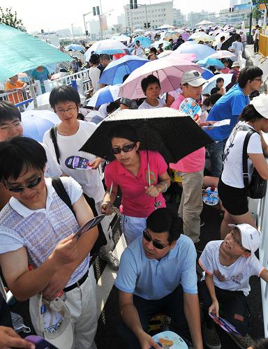 8月14日,在上海世博園五號門外,游客排隊等待開園。新華社記者 丁海濤 攝