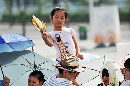 8月14日,在上海世博園五號門外,一名小游客在等待開園。新華社記者 丁海濤 攝