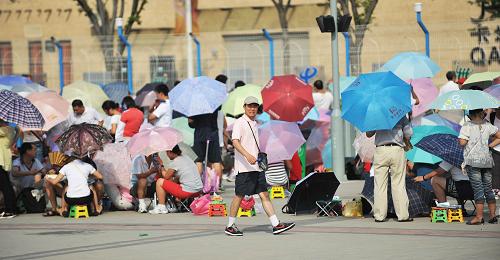 8月14日,游客在上海世博園五號門外等待開園。新華社記者 丁海濤 攝