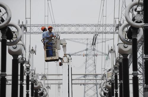 9月27日,安徽送變電工程公司的工作人員在對電氣設備做投入運行前的最后檢查。新華社記者 李健 攝
