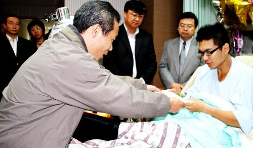 11月1日,游客家屬代表潘建輝探望受傷臺(tái)灣搜救人員周佑慶,為他送上家屬慰問(wèn)信和慰問(wèn)金。新華社記者 任沁沁 攝