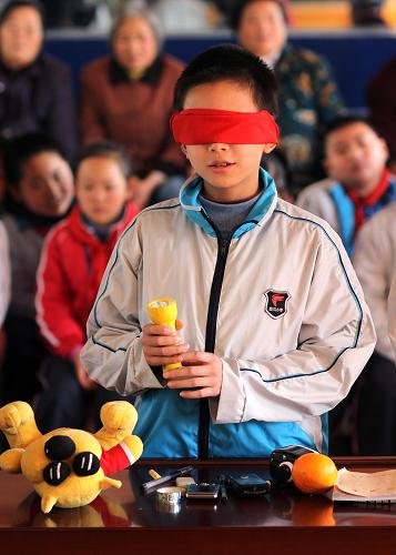 12月3日,南通虹橋第二小學(xué)的一名小學(xué)生在“蒙眼識(shí)物”項(xiàng)目的比賽中通過(guò)觸覺(jué)識(shí)別物品。新華社發(fā)(黃哲 攝)