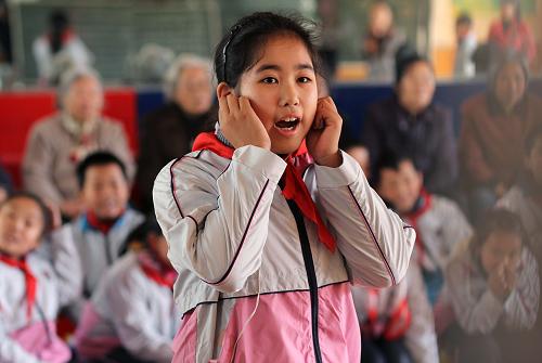 12月3日,南通虹橋第二小學(xué)的一名小學(xué)生在“猜猜說(shuō)的啥”項(xiàng)目的比賽中戴著耳機(jī)根據(jù)同伴口型判斷他的說(shuō)話(huà)內(nèi)容。新華社發(fā)(黃哲 攝)