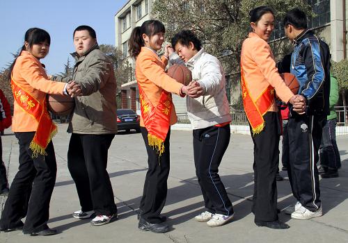 12月3日,在棗莊市市中區(qū)特殊教育中心,志愿者與智障學(xué)生一起做“牽手運(yùn)球”游戲。新華社發(fā)(孫中喆 攝)