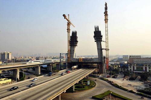 12月28日,建設(shè)中的貴廣鐵路跨穗鹽路斜拉橋,武廣高鐵動(dòng)車組從其旁邊駛過(guò)。當(dāng)日, 國(guó)家“十一五”規(guī)劃重點(diǎn)項(xiàng)目,貴(陽(yáng))廣(州)南(寧)廣(州)鐵路廣州樞紐控制性工程——跨穗鹽路斜拉橋主塔下橫梁混凝土澆筑完成,標(biāo)志著貴廣南廣廣州樞紐工程取得重要進(jìn)展??缢臌}路斜拉橋設(shè)計(jì)全長(zhǎng)415.2米,為國(guó)內(nèi)首座鐵路四線曲線斜拉橋,是新建貴廣南廣鐵路的控制性工程。新華社記者 梁旭 攝