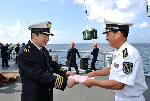 1月26日,中國海運(yùn)總公司“新赤灣”輪船長張國斌(左)向海軍第七批護(hù)航編隊(duì)保障指揮所指揮員潘志強(qiáng)轉(zhuǎn)交慰問信和慰問物資清單。新華社記者范軍威攝