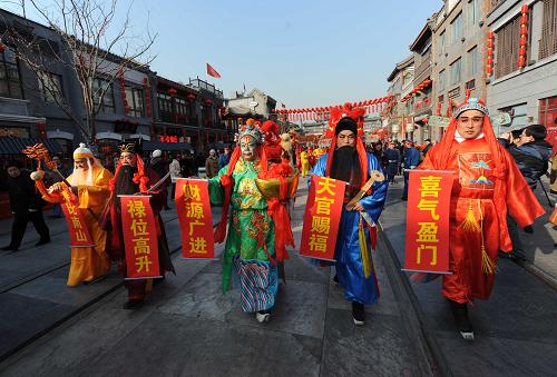 1月26日,北京前門大街天街年市上,演員在表演“五福送財(cái)”向過(guò)往游人拜早年。新華社發(fā)