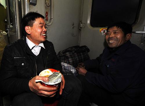 1月29日,在大同至杭州的K894次列車上,來自安徽桐城市的農(nóng)民工嚴(yán)壽培(左)和來自安徽利辛縣的農(nóng)民工李丙超在一起。由于沒有買上座位票,他們棲身在列車的車廂連接處。嚴(yán)壽培在山西太原一家烤雞店工作,他告訴記者,他專門給老婆孩子帶了4只他親手烤制的烤雞。新華社記者 燕雁 攝