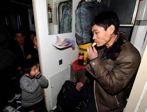 1月29日,在大同至杭州的K894次列車上,來自安徽阜陽的農(nóng)民工張啟武(右)和兒子張想在一起。由于沒有買上座位票,父子倆只能棲身在列車洗漱臺(tái)旁。張啟武長年在山西太谷縣務(wù)工,家中78歲的老母親是他最大的牽掛。新華社記者 燕雁 攝
