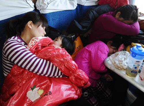 1月29日,在大同至杭州的K894次列車上,一個(gè)小女孩在母親懷中不愿入睡。新華社記者 燕雁 攝