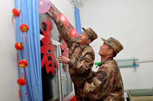 1月29日,5390前哨戰(zhàn)士將自己制作的春節(jié)裝飾品掛在墻上??錾礁沟氐奶煳狞c(diǎn)邊防連5390前哨官兵在完成邊防執(zhí)勤任務(wù)之余,自己動(dòng)手寫對(duì)聯(lián)、貼窗花、拉彩旗、掛燈籠,把營區(qū)和寢室打扮得喜氣洋洋,以高原邊防軍人特有的方式迎接兔年春節(jié)的到來。5390前哨以駐地海拔高度命名,這里年平均氣溫零度以下,空氣中的含氧量不足平原地區(qū)一半。官兵常年在異常惡劣的自然環(huán)境中戰(zhàn)嚴(yán)寒、斗缺氧,每年都圓滿完成上級(jí)賦予的各項(xiàng)任務(wù)。新華社發(fā)(向文軍 攝)
