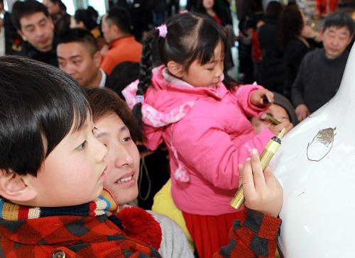 農(nóng)歷大年初一,小游客在上海金茂大廈88層觀光廳的“玉兔”身上寫下自己的心愿(2月3日攝)。新華社記者 張明 攝