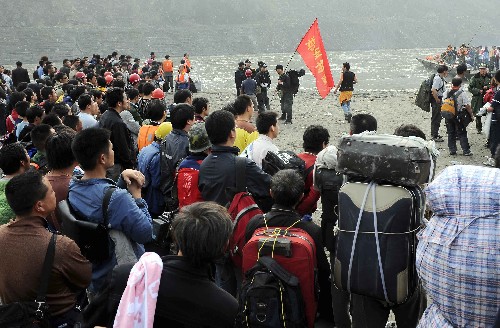 5月16日,汶川的受災(zāi)群眾在解放軍戰(zhàn)士的幫助下,經(jīng)過長途跋涉陸續(xù)到達位于阿壩鋁廠旁邊的臨時登陸口,等候上船。 新華社記者 陳凱 攝