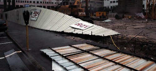 6月25日,澳門一處工地圍欄被吹倒。當(dāng)日清晨,2008年第6號(hào)強(qiáng)熱帶風(fēng)暴“風(fēng)神”掠過澳門。受狂風(fēng)暴雨影響,澳門中小學(xué)及幼兒園暫時(shí)停課,部分航班不能正常起降,往來澳門與香港間的客輪全面停航,穿梭于港澳之間的直升機(jī)停飛。 新華社記者劉衛(wèi)國攝