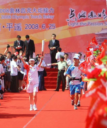 6月25日,火炬手王朝麗在進(jìn)行傳遞。當(dāng)日,北京奧運(yùn)會(huì)圣火在山西平遙傳遞。 新華社記者邢廣利攝