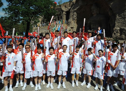 6月26日,部分火炬手在云崗石窟前合影留念。當(dāng)日,北京奧運(yùn)圣火在山西大同傳遞。 新華社記者江宏景攝