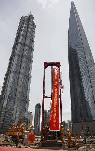 中國第一高樓上海中心主樓樁基工程竣工 7月18日,施工人員正在澆筑上海中心大廈主樓樁基工程最后一根樁基。 當(dāng)日,中國第一高樓上海中心大廈主樓樁基工程正式竣工。主樓樁基工程共打下了955根樁,每根樁直徑1米,深86米,單樁承載力達(dá)到2800噸。設(shè)計(jì)總高度達(dá)632米的上海中心大廈將于2014年竣工交付使用,它將超過420.5米的金茂大廈和492米的上海環(huán)球金融中心,成為中國第一高樓,也將成為完全符合“綠色建筑”標(biāo)準(zhǔn)的摩天大樓。 新華社記者 裴鑫攝