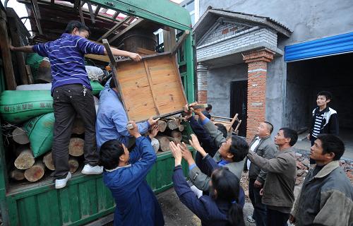 搬到荊門市葉坡安置點(diǎn)的移民們?cè)诨ハ鄮兔π遁d家具(10月20日攝)。 10月20日,丹江口市習(xí)家店鎮(zhèn)的第四批94戶庫(kù)區(qū)移民一起搬遷到湖北省荊門市的屈家?guī)X管理區(qū)。走出大山,來(lái)到新移民安置點(diǎn)的南水北調(diào)庫(kù)區(qū)移民開始了新的生活,逐步走向安居樂業(yè)。 搬進(jìn)新居的第一天,移民們開始布置新家,并在新家里吃上了第一頓飯。條件還有些簡(jiǎn)陋,家里還有些凌亂,移民們還顯得有些忙碌和陌生。但是新的一切畢竟拉開了帷幕。生活方式改變了——原先靠養(yǎng)魚和種植柑桔致富的他們,搬進(jìn)了樓房,用上了自來(lái)水,并在已經(jīng)分得的菜地里開始習(xí)慣著耕種生活。對(duì)于庫(kù)區(qū)移民們來(lái)說(shuō),新的生活才剛剛開始。 新華社記者李曉果攝