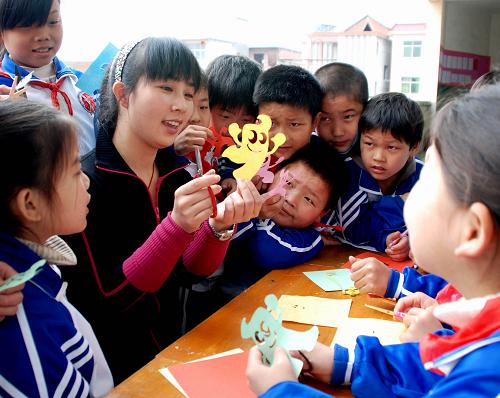 4月26日,在江西樂平市塔山街道天濟(jì)小學(xué),老師張佳教學(xué)生制作海寶剪紙,迎接世博會的到來。 新華社發(fā)(朱定文 攝)