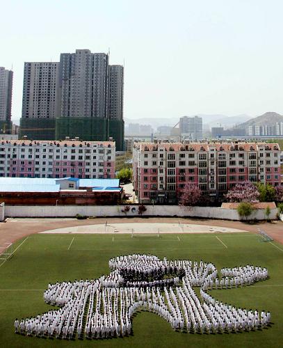 4月26日,山東省濟(jì)南市歷城區(qū)第五中學(xué)學(xué)生在操場排成上海世博會吉祥物“海寶”造型的隊形,表達(dá)對世博會的期盼與祝福。 新華社發(fā)(趙曉明 攝)