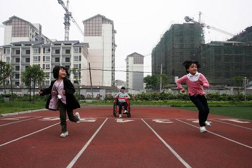 都江堰:新居在廢墟上崛起 5月7日,幾名女學(xué)生在學(xué)校操場(chǎng)上賽跑,她們身后是在建的永久性安居住房。 “5·12”特大地震使四川省都江堰市城鎮(zhèn)住房嚴(yán)重受損,共有10.89萬(wàn)個(gè)家庭、30余萬(wàn)人的住房不同程度地遭到破壞。曾經(jīng)物華天寶、山清水秀的小城,在短短的80秒地震后,變成了滿目瘡痍、傷痕累累的極重災(zāi)區(qū)。 “宅是人之本,人以宅為家,居若安,家能昌吉,居不安,則家衰敗”。都江堰人深諳此話深意,通過(guò)一年多的艱辛與努力,今天的都江堰市城鎮(zhèn)住房恢復(fù)重建已取得重大階段性成效。一棟棟地震毀損房屋被拆除,一批批永久性安居住房拔地而起,一個(gè)個(gè)居民自建點(diǎn)陸續(xù)竣工…… 新華社記者鄭悅攝