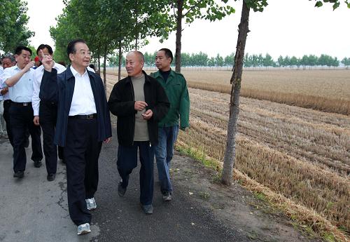 6月9日至10日,中共中央政治局常委、國(guó)務(wù)院總理溫家寶來(lái)到河南省鄭州、許昌等地,深入麥田、農(nóng)戶和糧庫(kù),實(shí)地察看小麥?zhǔn)崭詈褪召?gòu)情況。他還主持召開(kāi)農(nóng)民和基層干部座談會(huì),就農(nóng)業(yè)農(nóng)村工作進(jìn)行調(diào)研。這是6月9日,溫家寶在長(zhǎng)葛市石象鄉(xiāng)坡李王村的田間小路上與坡李王村支部書(shū)記李福成邊走邊聊。新華社記者 龐興雷 攝