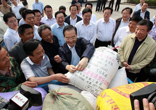 這是6月10日,在許昌新興國(guó)家糧食儲(chǔ)備庫(kù)門(mén)前,溫家寶向前來(lái)賣(mài)糧的靈井鄉(xiāng)劉莊村的村民們了解小麥產(chǎn)量、價(jià)格以及收購(gòu)情況。 新華社記者龐興雷攝