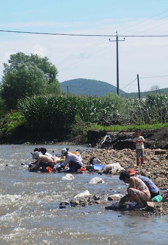 8月6日,樺甸市常山鎮(zhèn)受災(zāi)群眾在河邊洗刷被洪水泡過(guò)的衣物。連續(xù)幾日的晴天使洪水退去后的吉林樺甸災(zāi)區(qū)恢復(fù)了以前的溫暖。受災(zāi)群眾也開(kāi)始忙活起來(lái),清理淤泥、整理雜物、晾曬衣物,開(kāi)始了災(zāi)后重建的生活。新華社記者 宗巍 攝